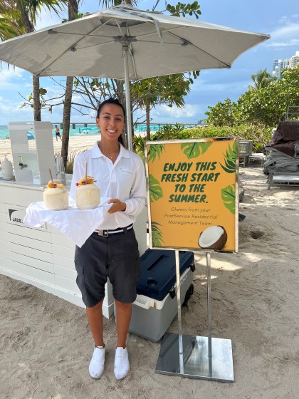 Female server with tropical drinks at the beach